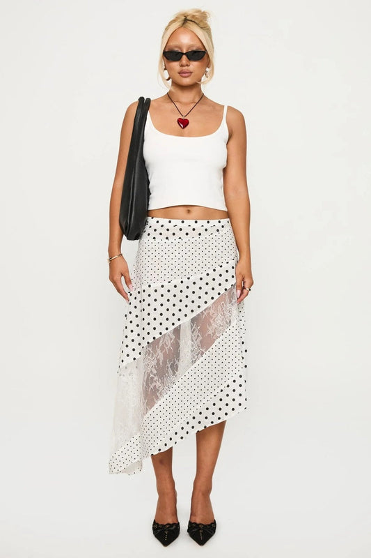 Woman in white tank top and polka dot and lace asymmetrical skirt