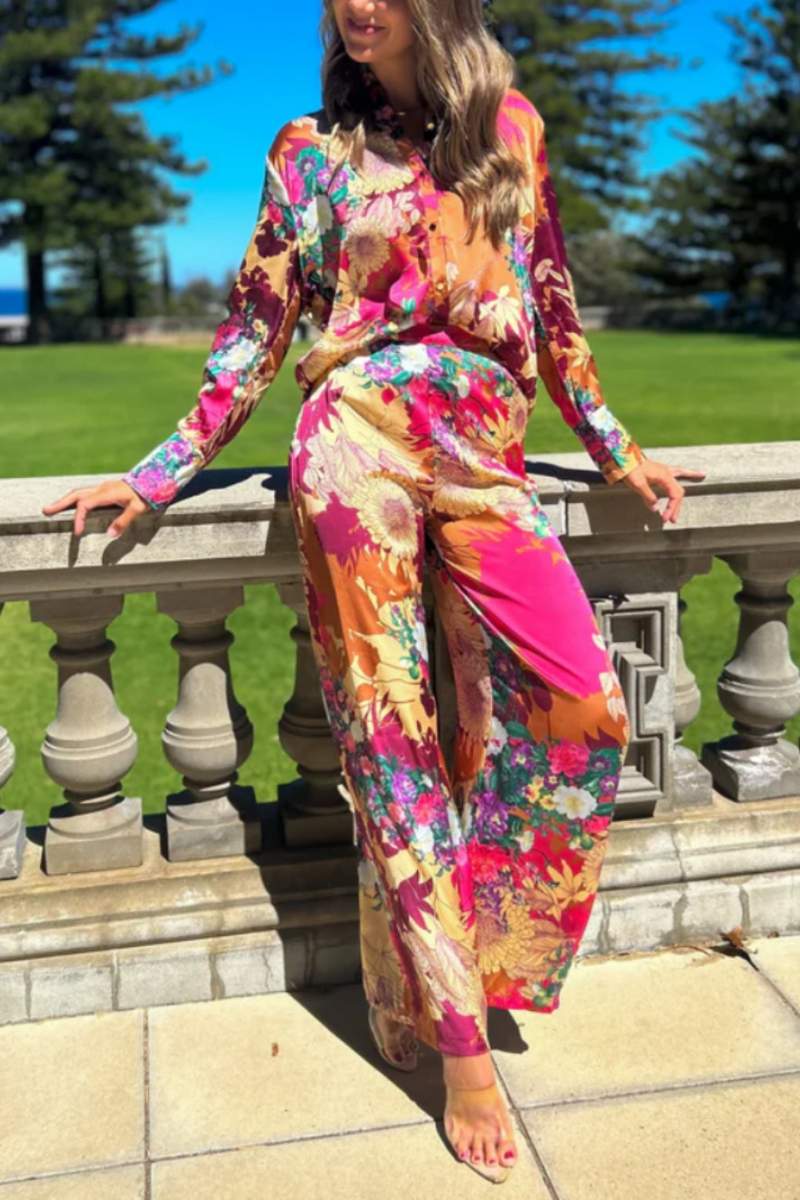 Woman in floral satin pantsuit standing on patio