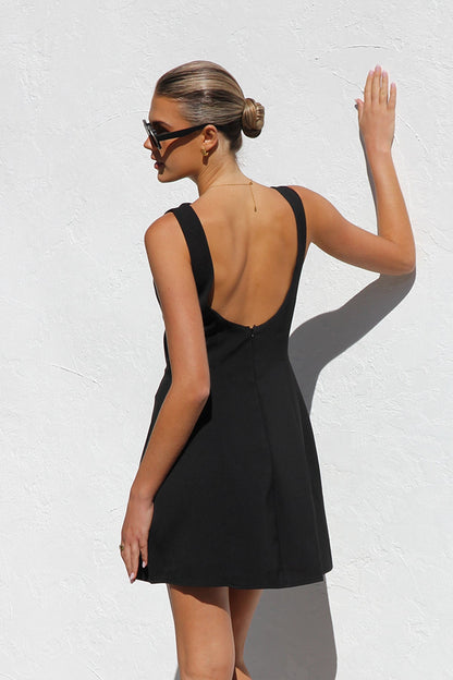Woman in black sleeveless woven mini dress