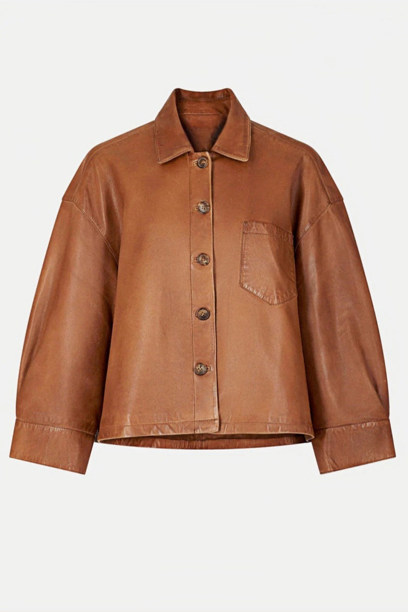 Woman wearing tan leather jacket and patterned sweater