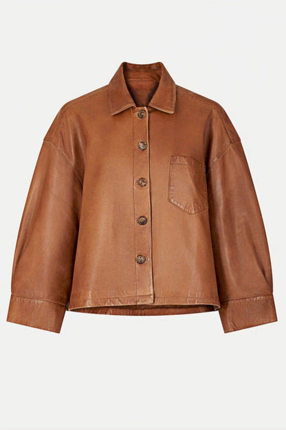 Woman wearing tan leather jacket and patterned sweater