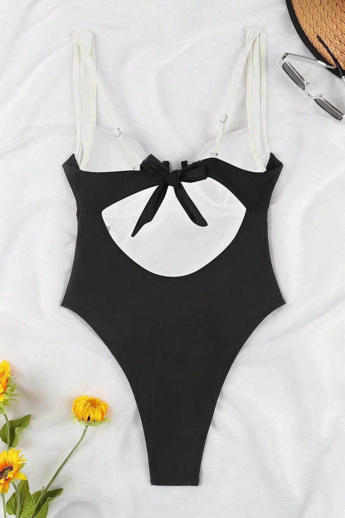 Woman in black and white one-piece swimsuit by the ocean