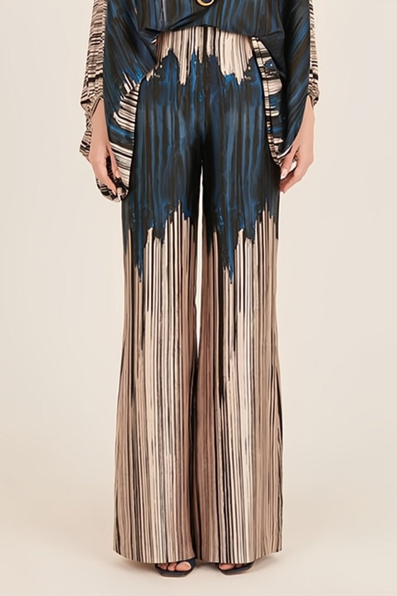 Woman wearing off-shoulder blue and beige abstract print silk jumpsuit