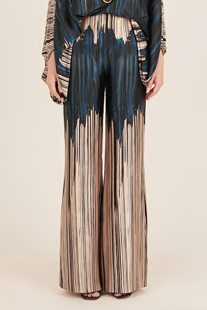 Woman wearing off-shoulder blue and beige abstract print silk jumpsuit