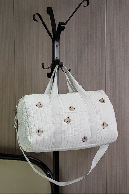 Off-white quilted barrel bag with bear embroidery hanging on coat rack