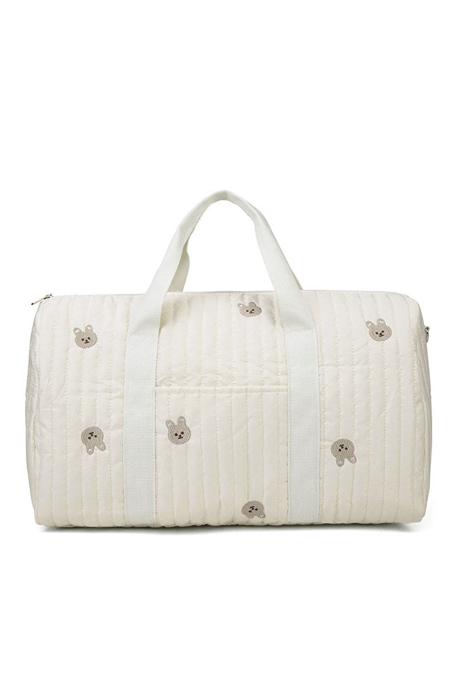 Off-white quilted duffle bag with teddy bear embroidery hanging on a coat rack