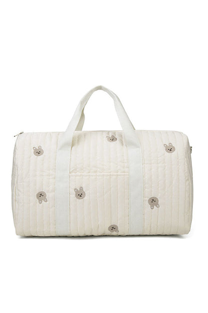 Off-white quilted duffle bag with teddy bear embroidery hanging on a coat rack