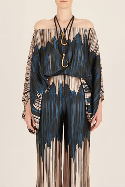 Woman wearing off-shoulder blue and beige abstract print silk jumpsuit