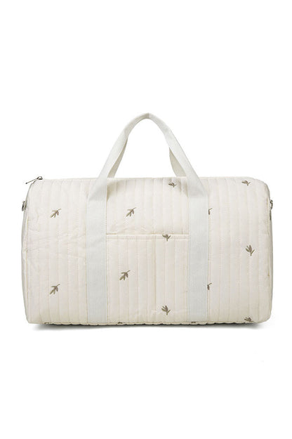 Off-white quilted duffle bag with teddy bear embroidery hanging on a coat rack