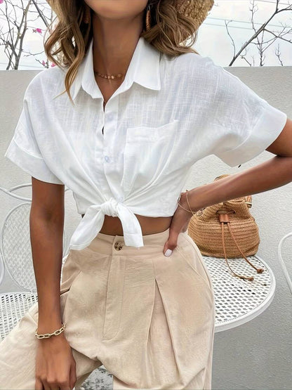 Woman wearing white linen short-sleeve shirt and beige pleated trousers