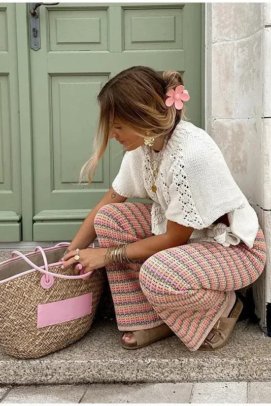 Woman in ivory crochet poncho with patterned pants