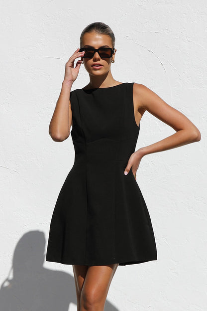 Woman in black sleeveless woven mini dress