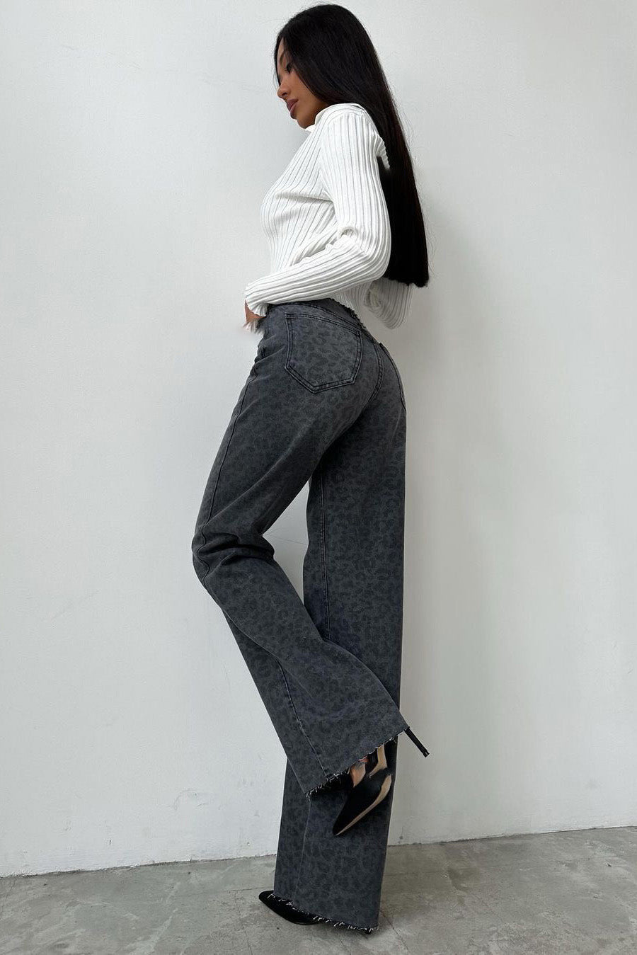 Woman in gray leopard print wide leg jeans and white ribbed knit top