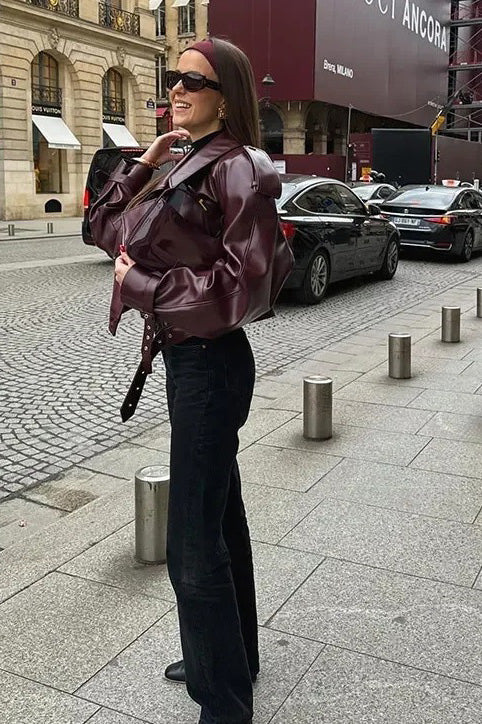 Woman in burgundy faux leather oversized jacket with matching headband and purse