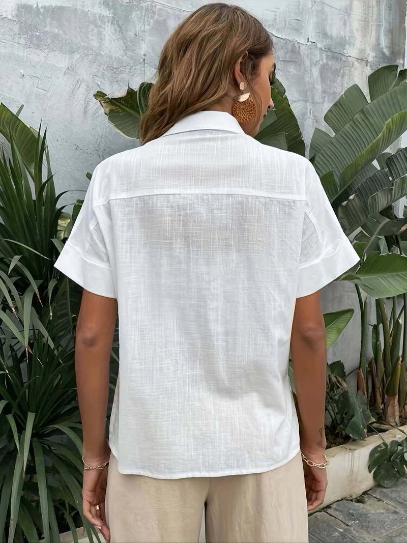 Woman wearing white linen short-sleeve shirt and beige pleated trousers