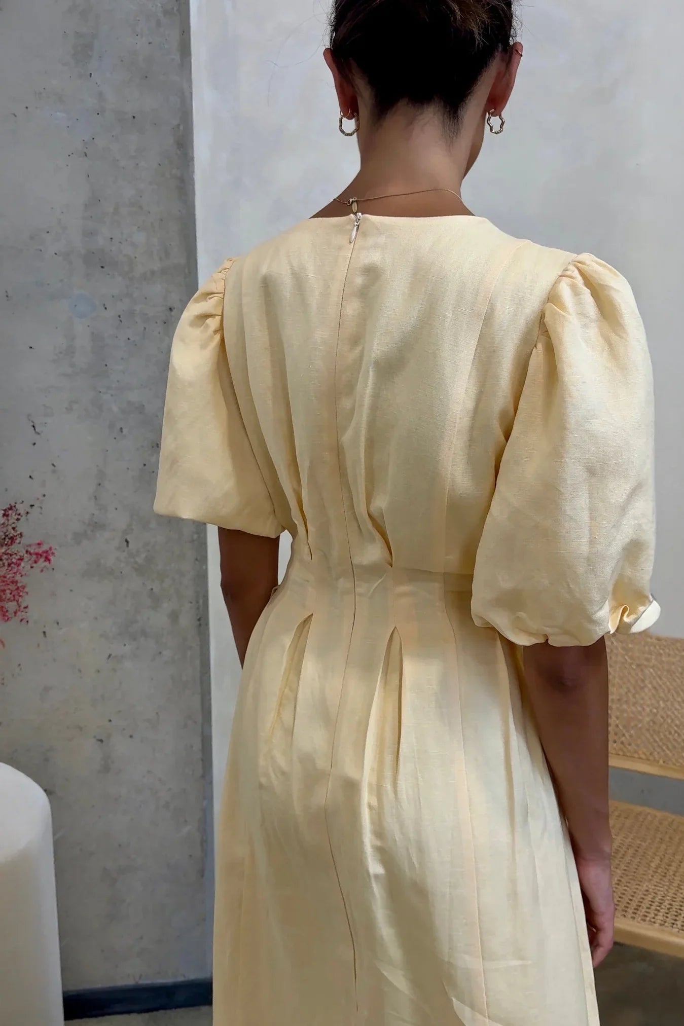 Woman in pale yellow linen maxi dress with puff sleeves