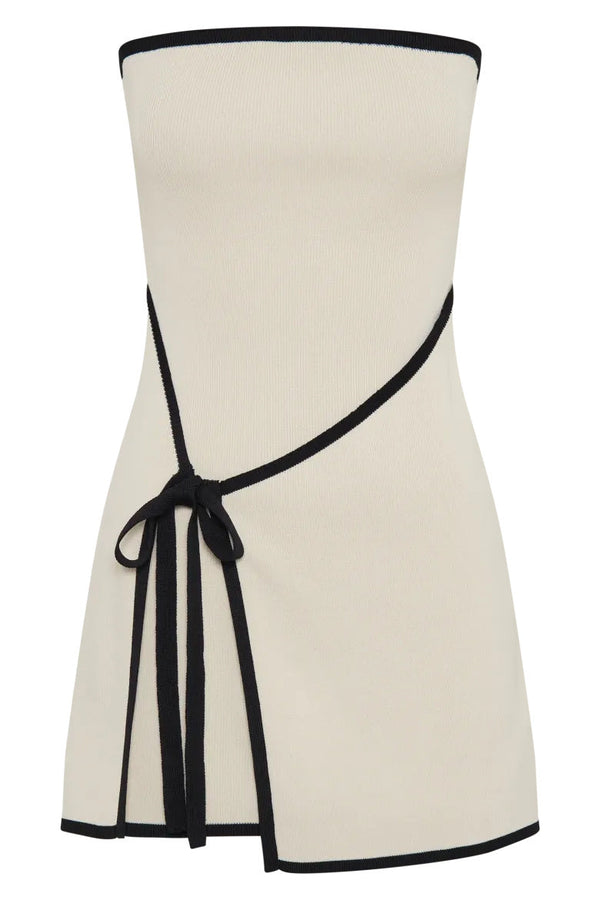 Woman wearing ivory ribbed knit strapless mini dress with black trim and tie waist.