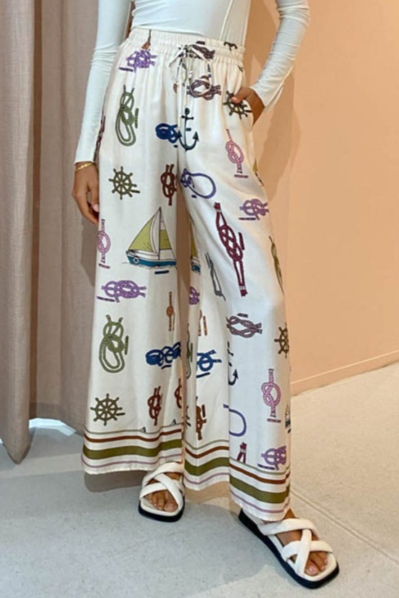 Woman wearing ivory satin pajama set with nautical print