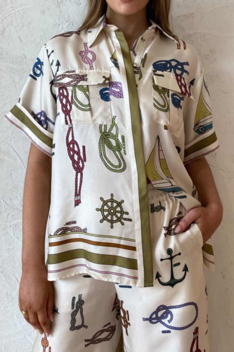 Woman wearing ivory satin pajama set with nautical print