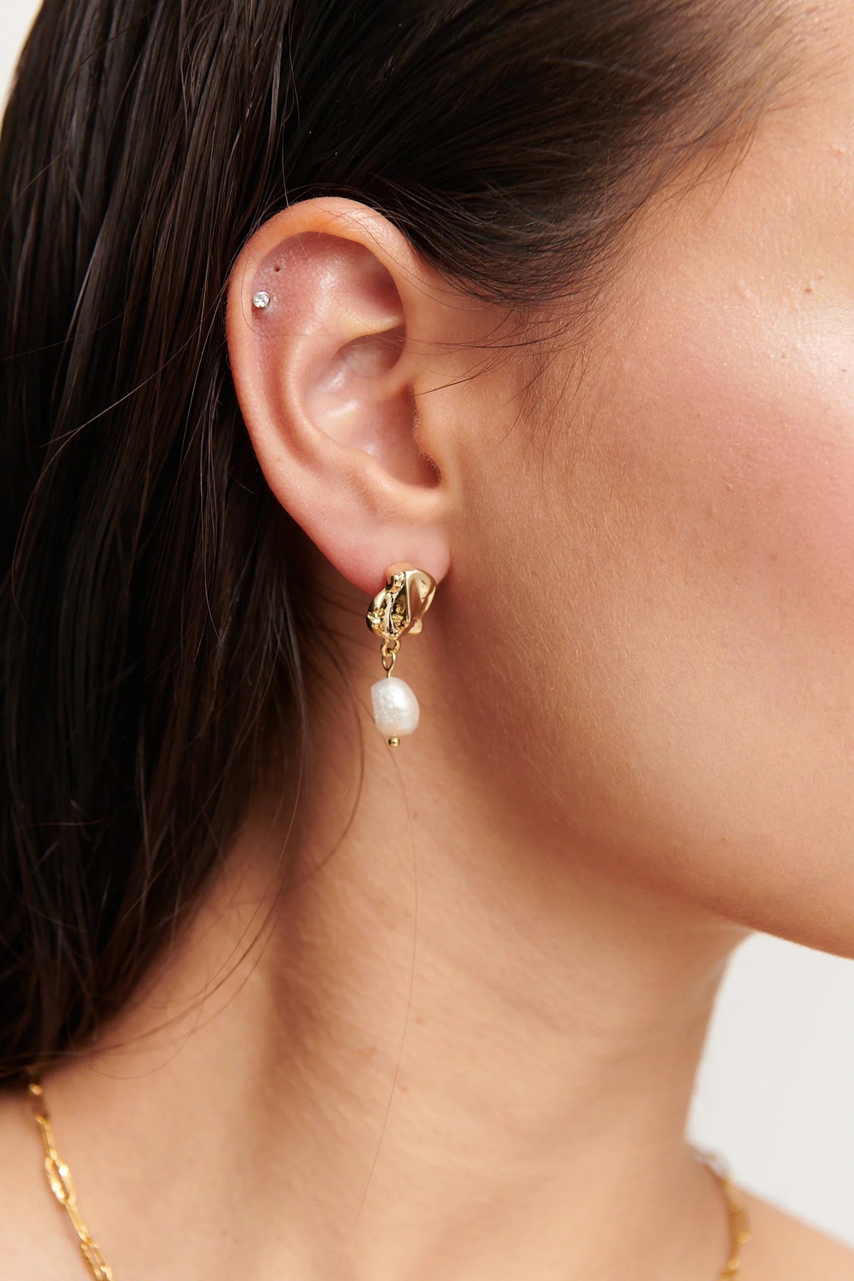 Close up of gold vermeil drop earrings with pearl