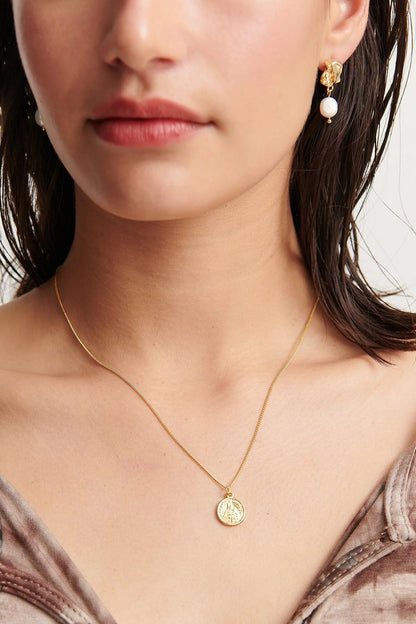Close up of gold vermeil drop earrings with pearl