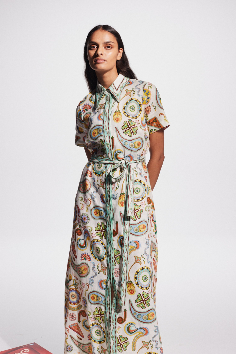 Woman in ivory paisley linen maxi dress with belt