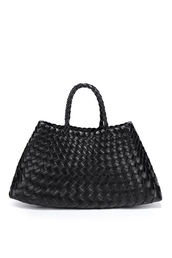 Woman holding brown woven tote bag