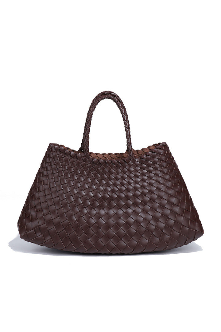 Woman holding brown woven tote bag