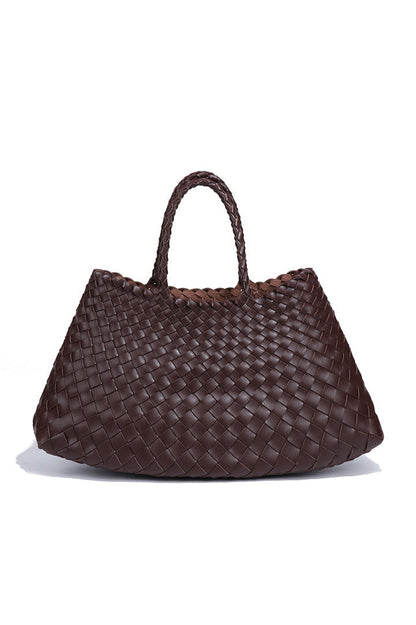 Woman holding brown woven tote bag