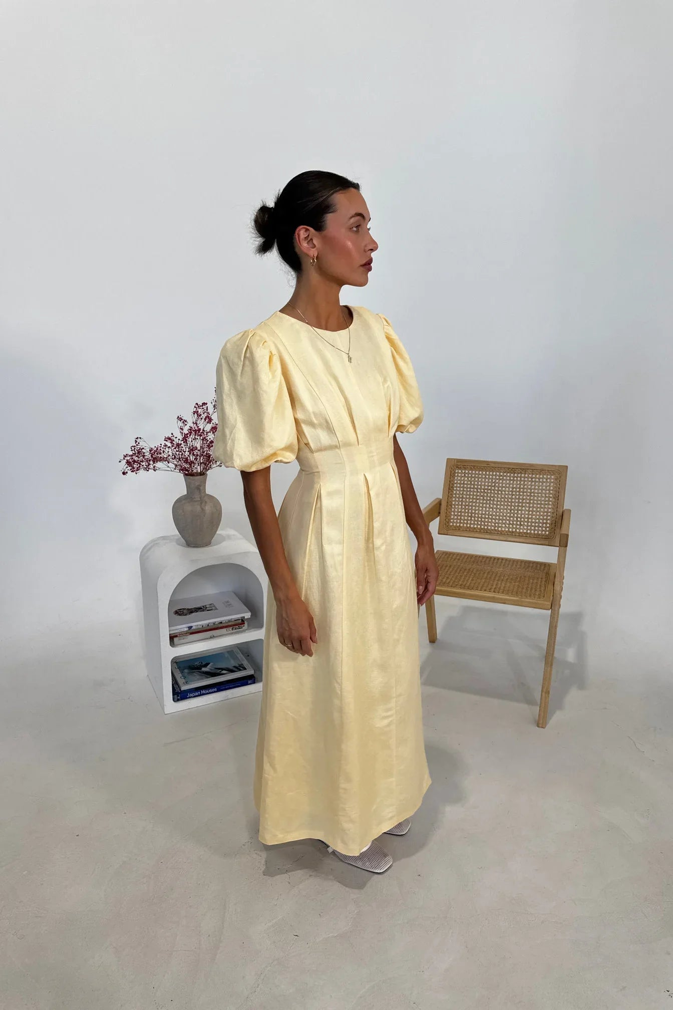 Woman in pale yellow linen maxi dress with puff sleeves