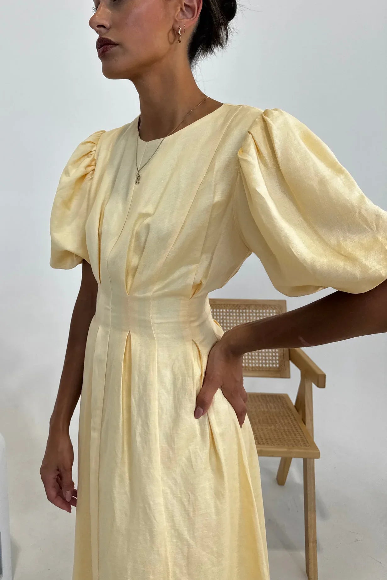 Woman in pale yellow linen maxi dress with puff sleeves