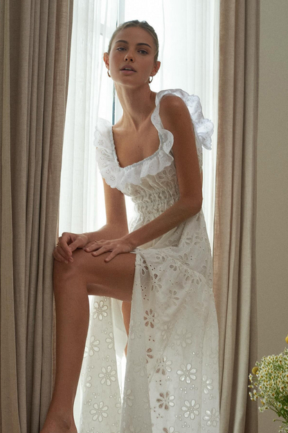 Woman in white eyelet maxi dress with ruffle sleeves