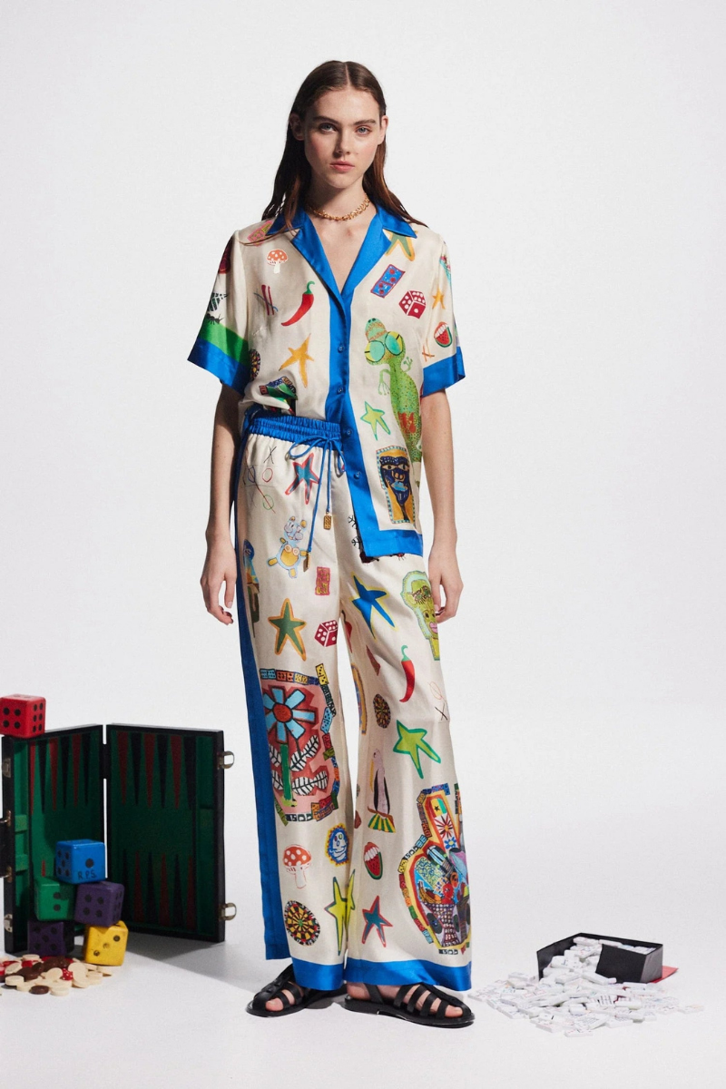 Woman in ivory silk pajama set with blue trim and novelty print