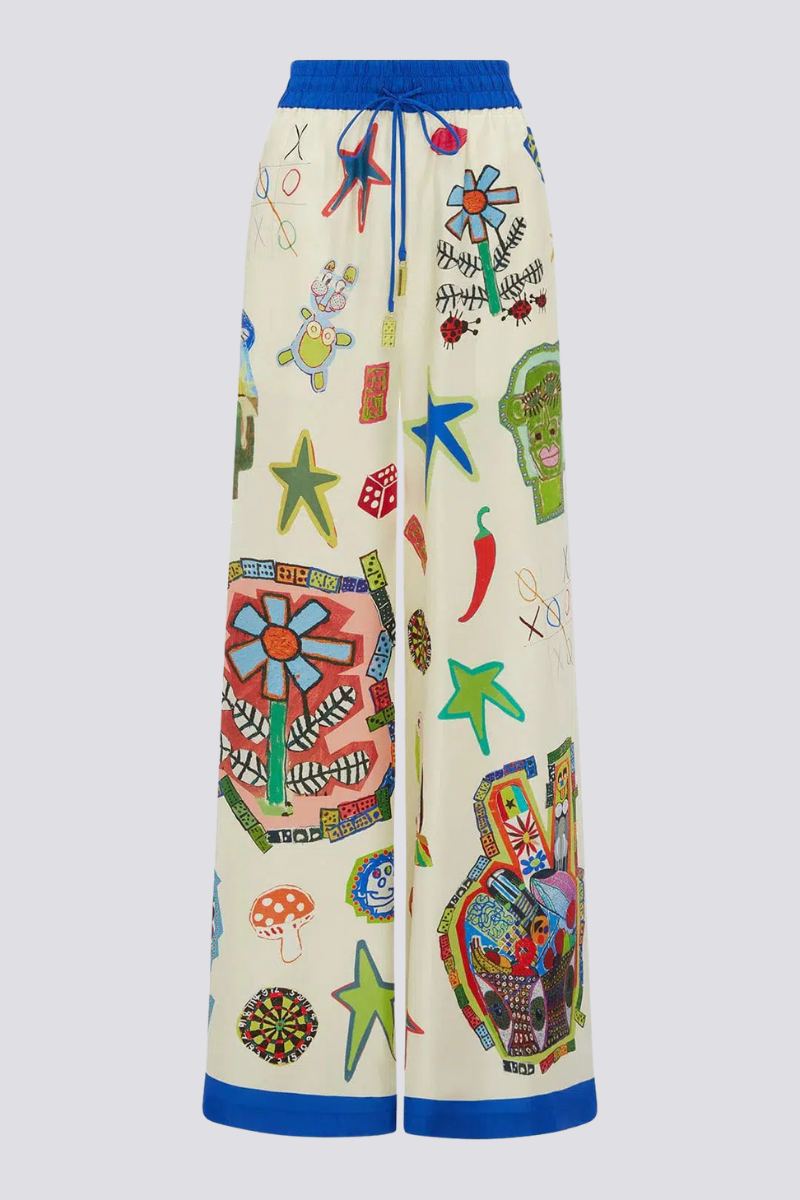 Woman in ivory silk pajama set with blue trim and novelty print