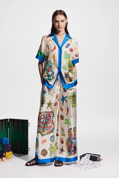 Woman in ivory silk pajama set with blue trim and novelty print