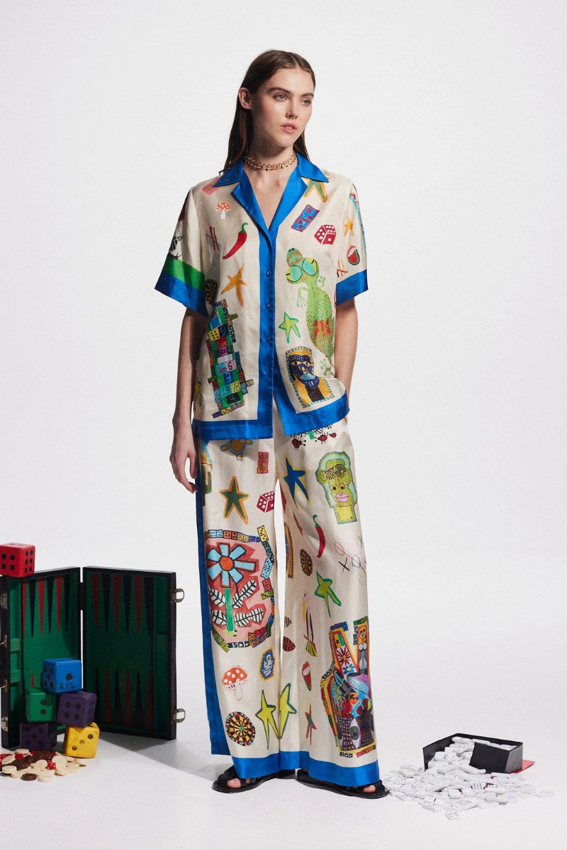 Woman in ivory silk pajama set with blue trim and novelty print