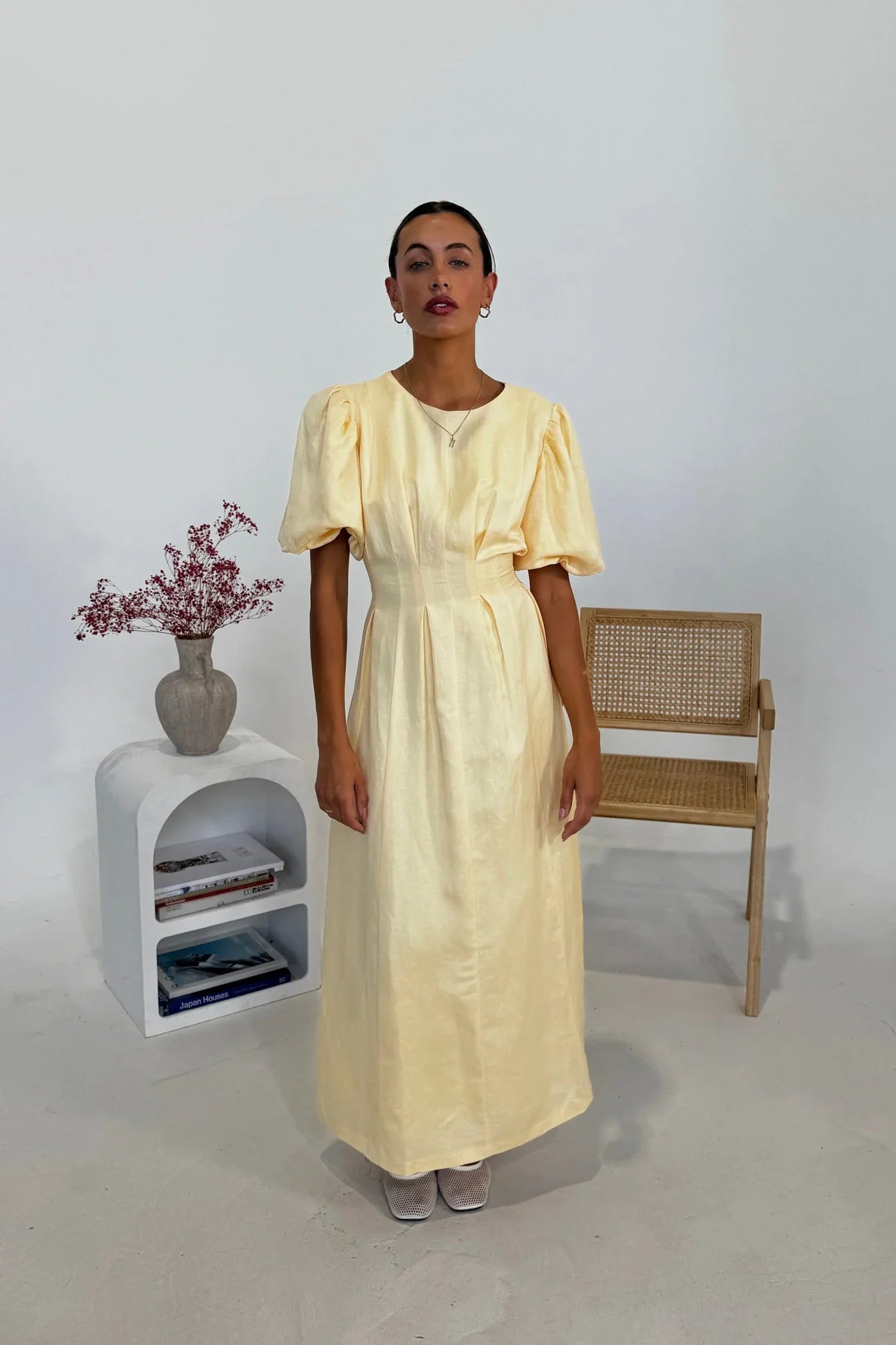 Woman in pale yellow linen maxi dress with puff sleeves