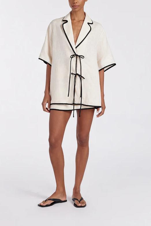 Woman wearing cream linen short set with black trim