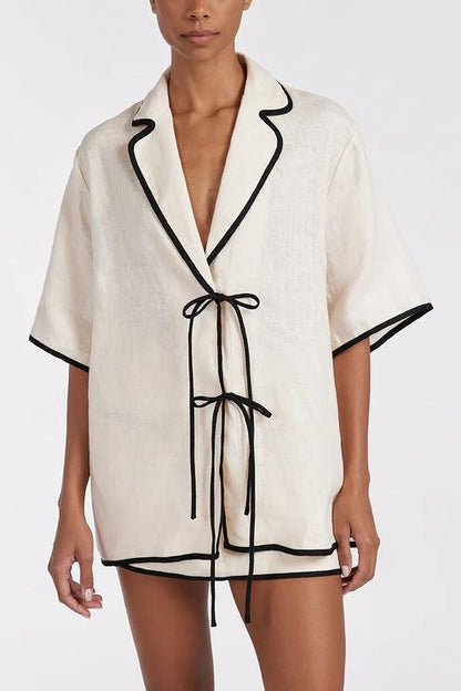 Woman wearing cream linen short set with black trim