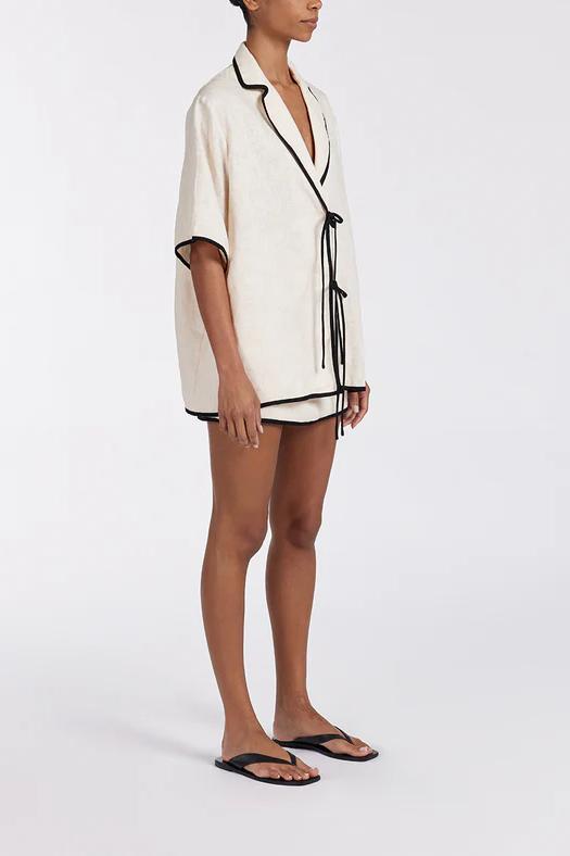 Woman wearing cream linen short set with black trim