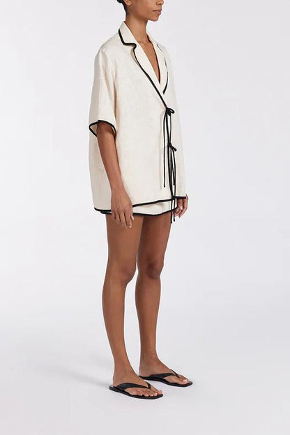 Woman wearing cream linen short set with black trim