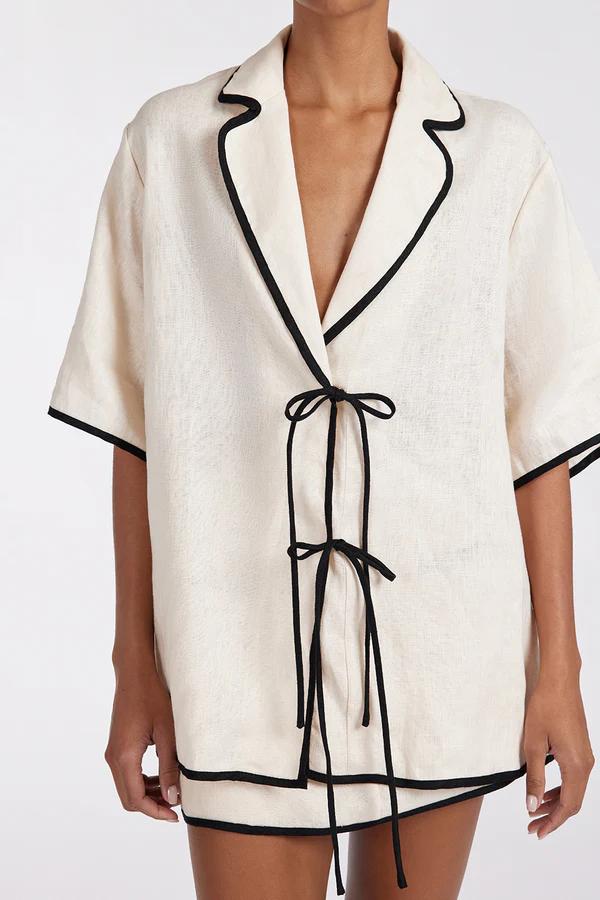 Woman wearing cream linen short set with black trim