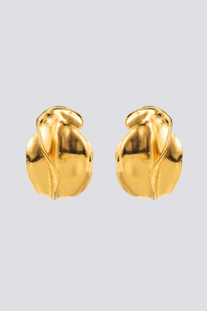 Close up of a gold abstract stud earring on an ear