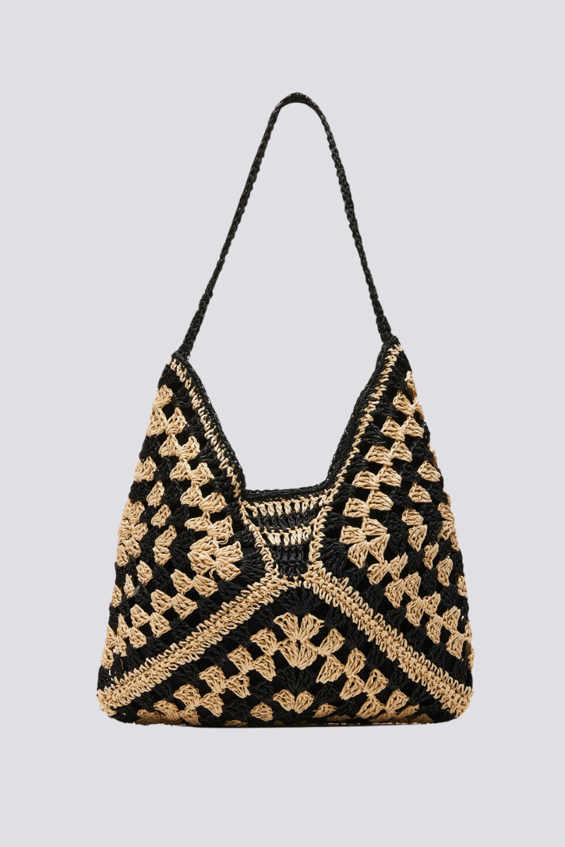 Woman holding a black and beige checkerboard crochet tote bag