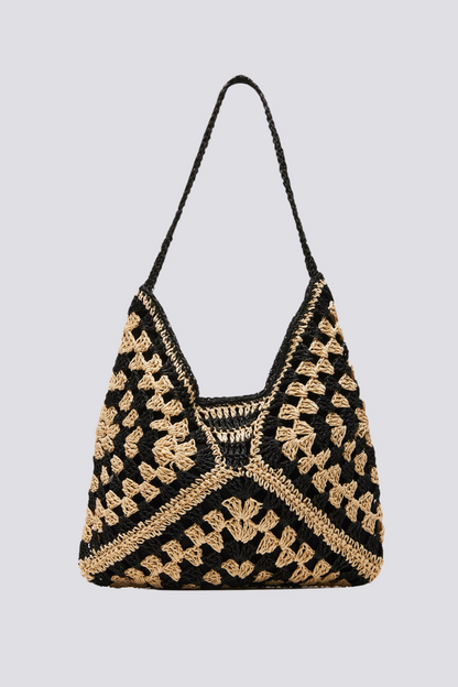 Woman holding a black and beige checkerboard crochet tote bag