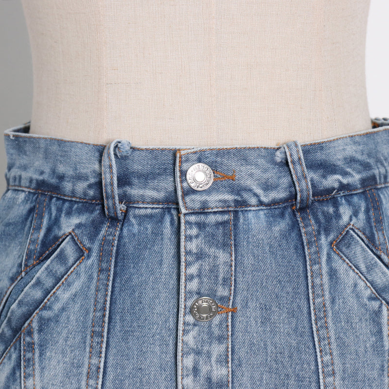 Woman wearing light wash denim skort with button detail