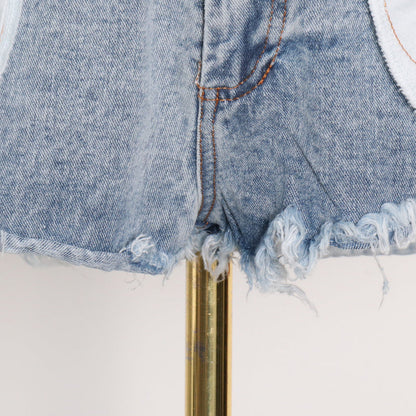Woman wearing light wash denim skort with button detail