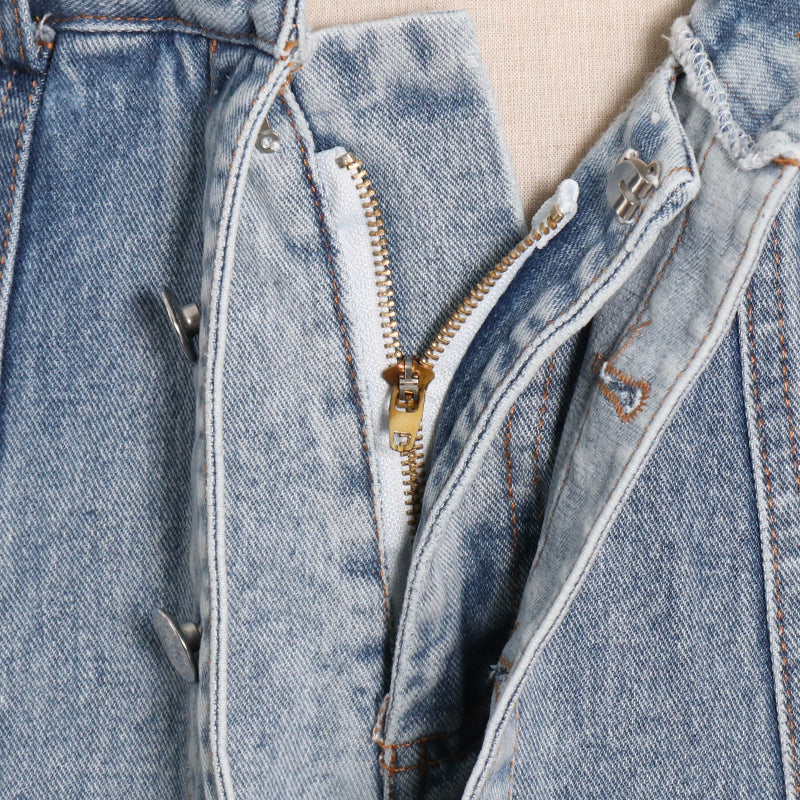 Woman wearing light wash denim skort with button detail