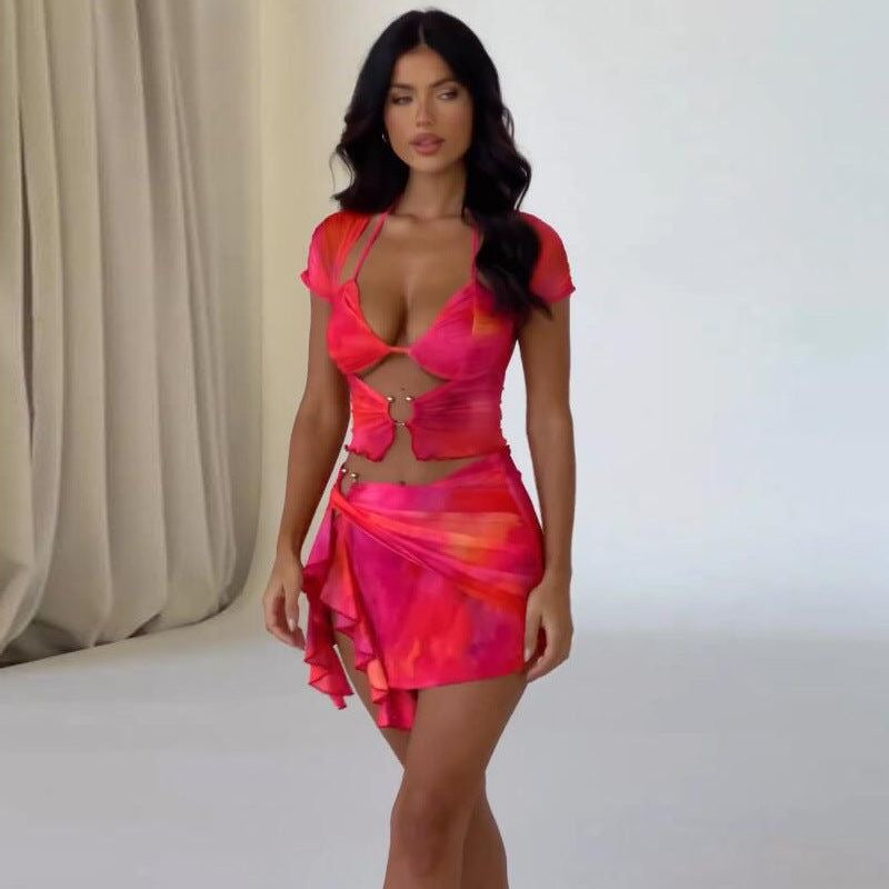 Woman in pink and orange mesh halter top and skirt set.