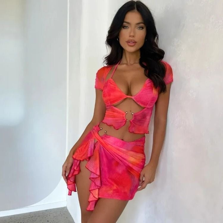 Woman in pink and orange mesh halter top and skirt set.
